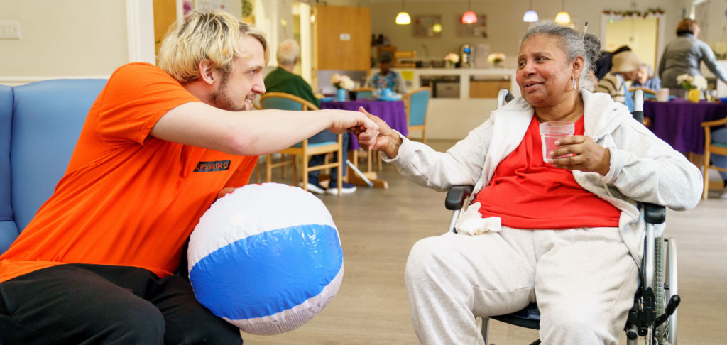 a circus workshop leader shakes hands with an older workshop participant